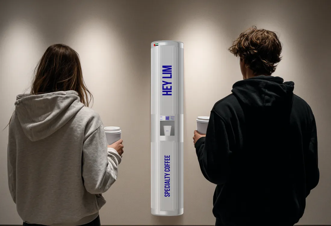 Two customers enjoying specialty coffee from a HEYLIM autonomous coffee machine in a modern gallery space